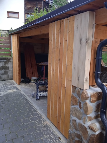 Vytvoření závětří a zátiší přístřešku ze smrkových trámů.