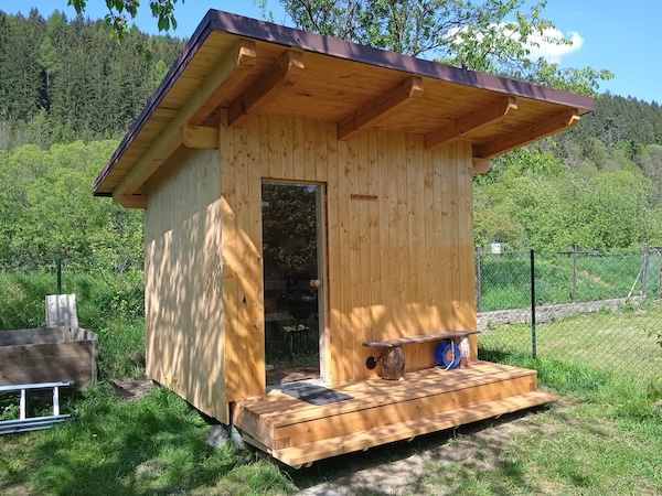 Stavba sauny s prostorem pro uskladnění dřeva na vytápění.