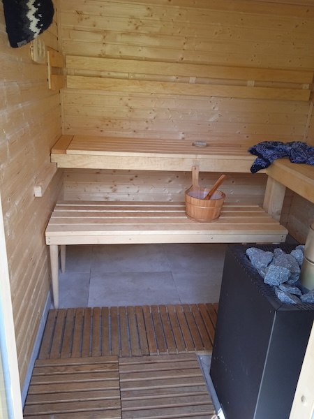 Stavba sauny s prostorem pro uskladnění dřeva na vytápění.