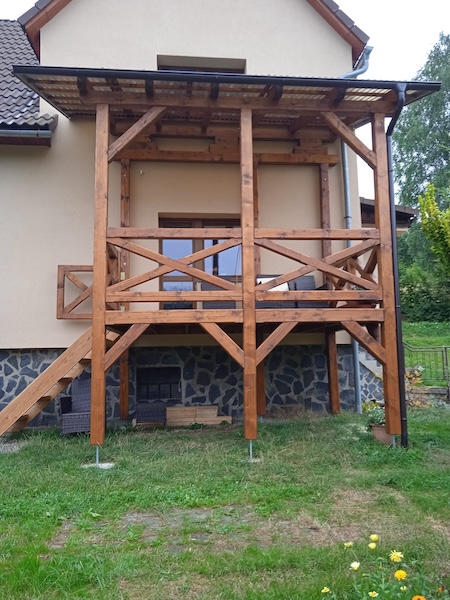 Krytá terasa v Kněhyních s modřínovým schodištěm.